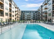 Thumbnail 3 of 53 - an apartment complex with a swimming pool in front of a building